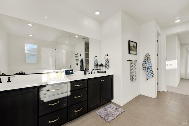 bathroom with tile patterned flooring, vanity, and walk in shower