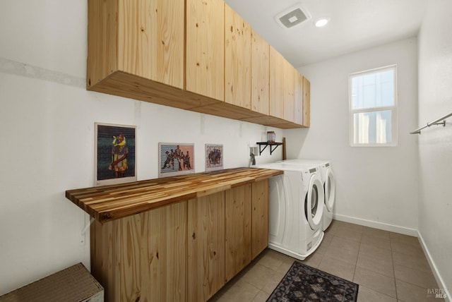 washroom with cabinets, washer and clothes dryer, and light tile patterned flooring