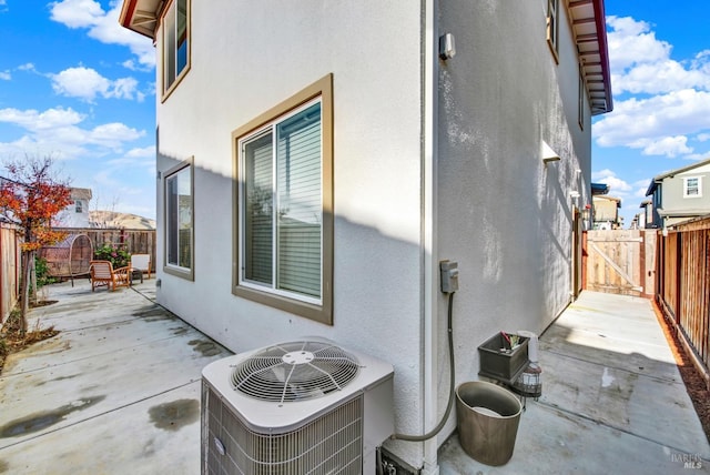 view of property exterior with central AC unit and a patio