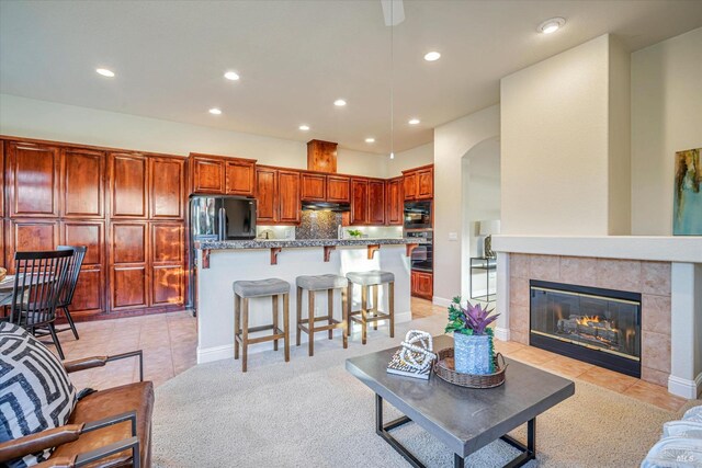 living room with light tile patterned floors and a fireplace