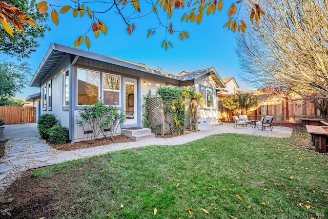 view of front of home with a front yard and a patio area