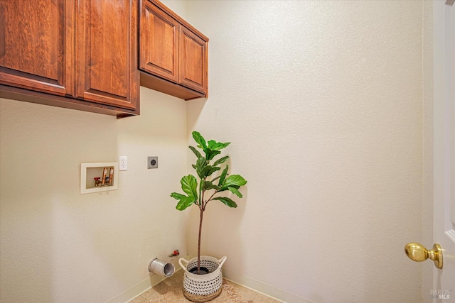 laundry room with cabinets, hookup for a washing machine, hookup for an electric dryer, light tile patterned floors, and gas dryer hookup