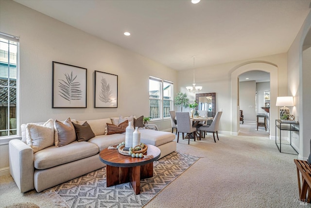 carpeted living room with a healthy amount of sunlight and a notable chandelier