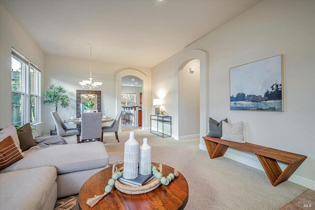 living room with light carpet and a notable chandelier