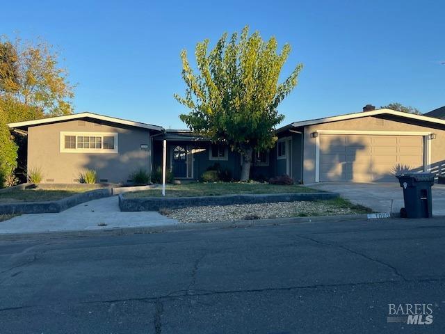 single story home with an attached garage, driveway, and stucco siding