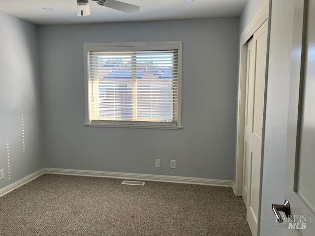 unfurnished bedroom with ceiling fan and carpet