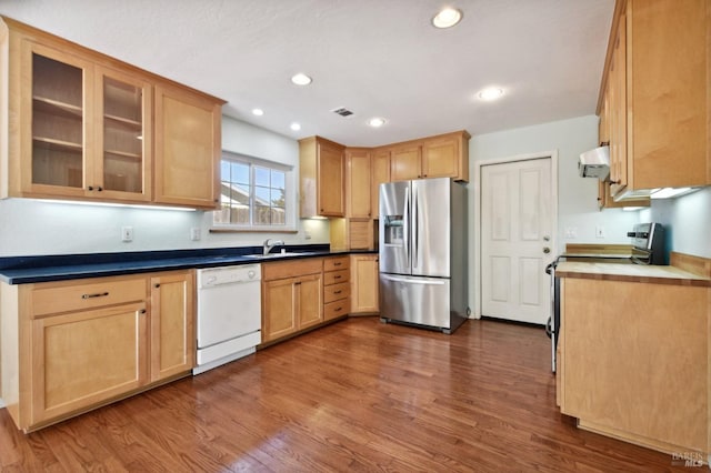 kitchen with stainless steel fridge, dark hardwood / wood-style flooring, white dishwasher, exhaust hood, and range with electric stovetop