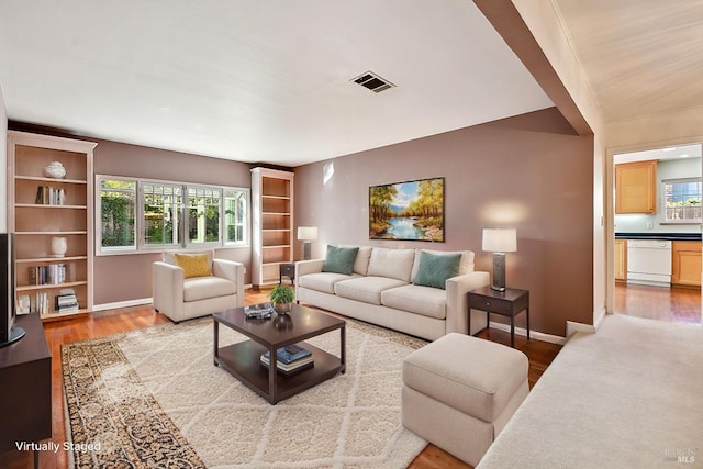 living room with hardwood / wood-style flooring, a wealth of natural light, and vaulted ceiling