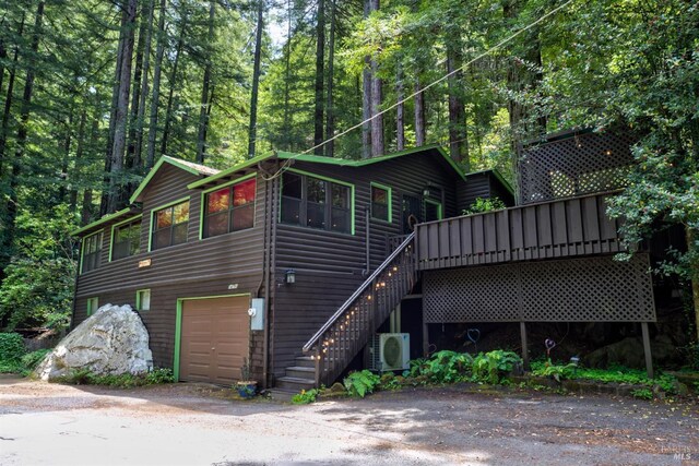 view of front of house with ac unit, a garage, and a wooden deck