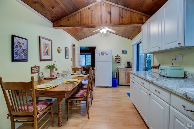 kitchen with light stone counters, light wood-style floors, freestanding refrigerator, wood ceiling, and white cabinetry