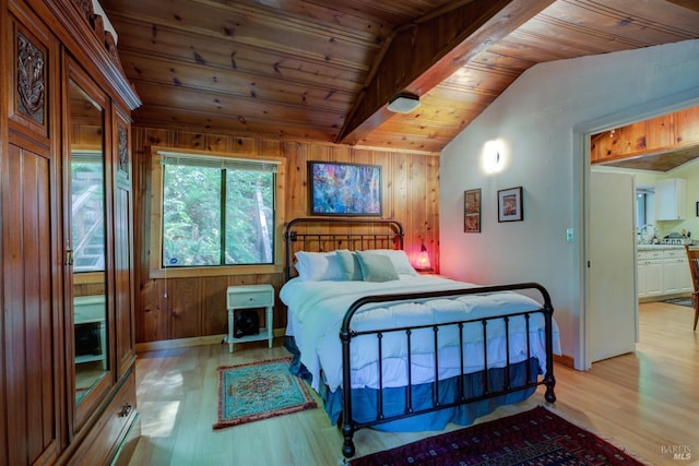 bedroom featuring lofted ceiling with beams, wooden ceiling, light wood-style flooring, and wood walls