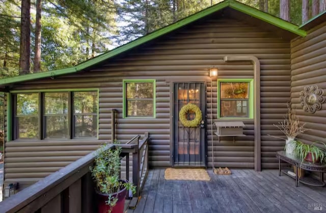 exterior space featuring a wooden deck and faux log siding