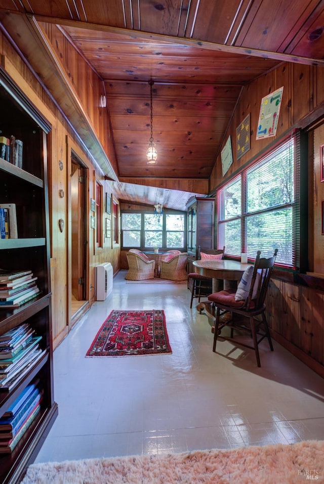 interior space with lofted ceiling, wood ceiling, and wooden walls