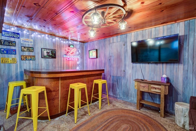 bar with wooden ceiling, light colored carpet, wooden walls, and a bar