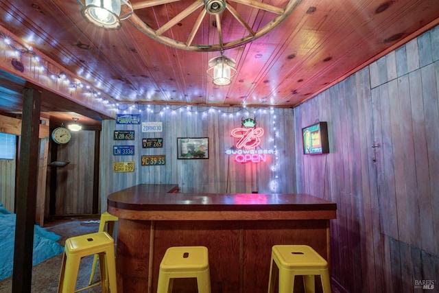 bar with wooden ceiling, wood walls, and a bar