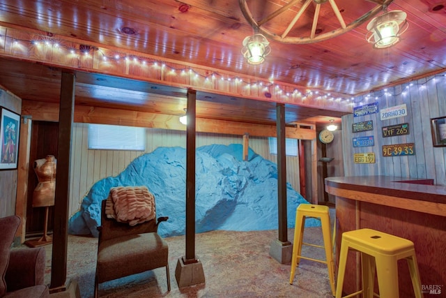 interior space with a dry bar, wooden ceiling, and wooden walls