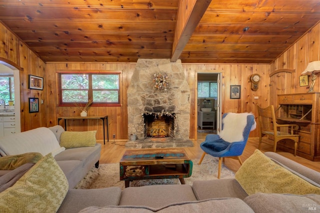 living area featuring wooden ceiling, a fireplace, a wealth of natural light, and wood finished floors