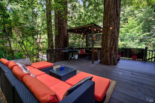 wooden terrace featuring a gazebo, an outdoor living space, and area for grilling