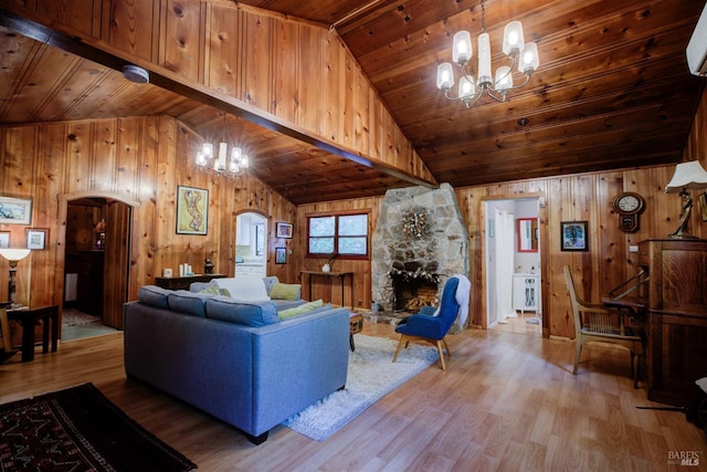 living area with a chandelier, wooden ceiling, a stone fireplace, and wood finished floors