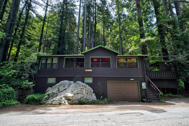 rustic home with stairway and an attached garage