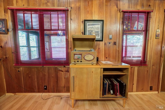 interior space with light wood-style floors, wooden walls, and baseboards