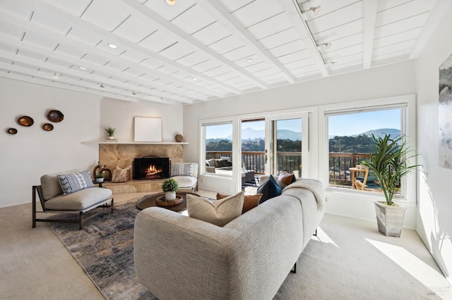 living room with a stone fireplace, light carpet, and a mountain view