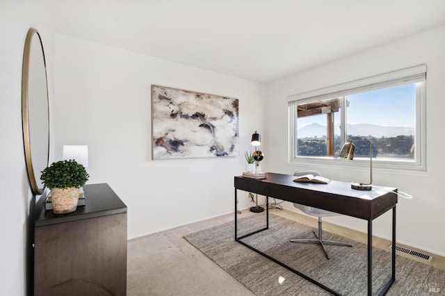 carpeted office space featuring a mountain view