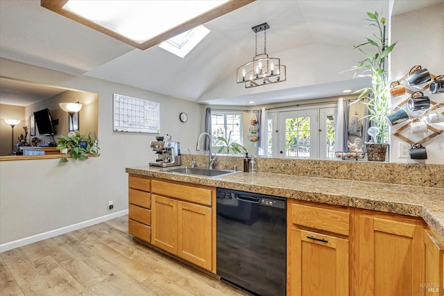 kitchen with tile counters, light wood-style floors, lofted ceiling with skylight, a sink, and dishwasher