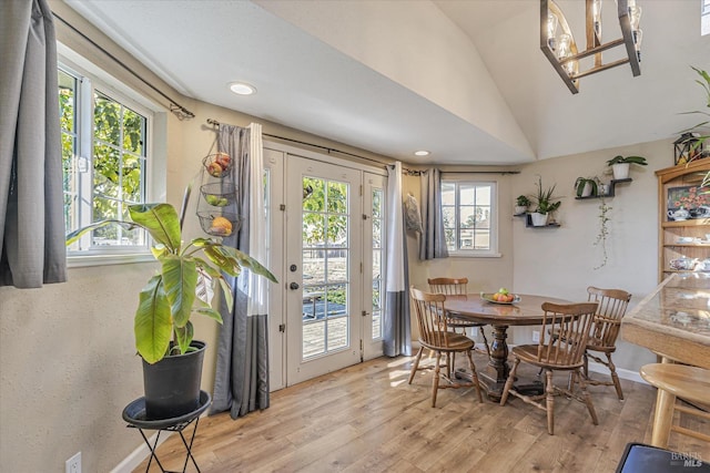 dining space featuring vaulted ceiling, light wood finished floors, and baseboards