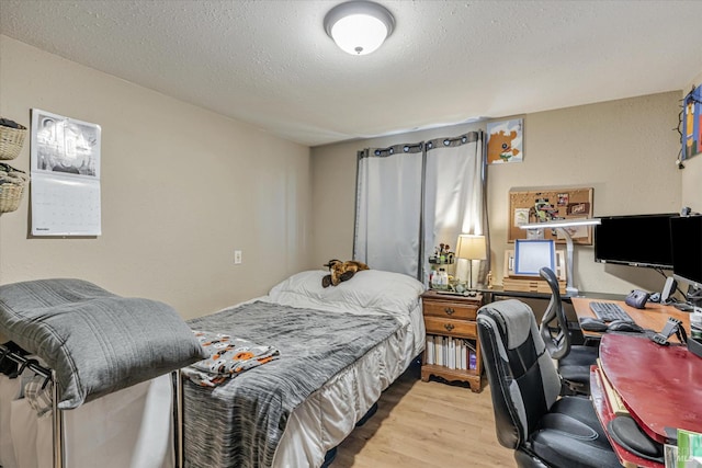 bedroom featuring a textured ceiling and wood finished floors