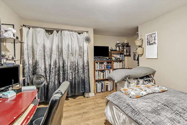 bedroom featuring a textured ceiling and wood finished floors