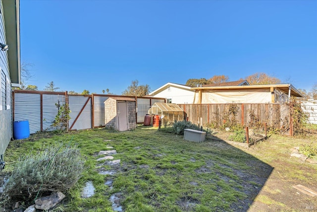 view of yard featuring a garden, a fenced backyard, and an outdoor structure