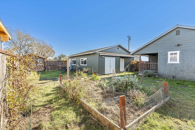 rear view of property featuring a fenced backyard, a lawn, and an outdoor structure