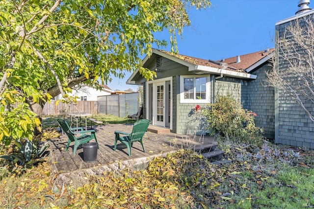 rear view of house featuring fence and a deck