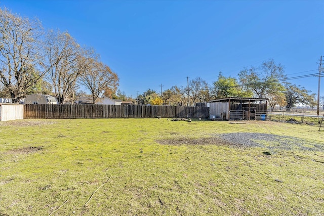 view of yard featuring an outbuilding and fence