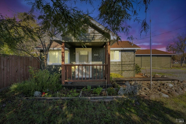 rear view of house with a porch and fence