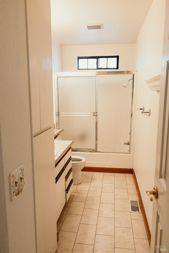 full bathroom with tile patterned flooring, vanity, combined bath / shower with glass door, and toilet