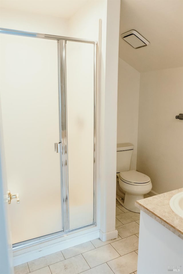 bathroom with toilet, vanity, tile patterned floors, and a shower with door