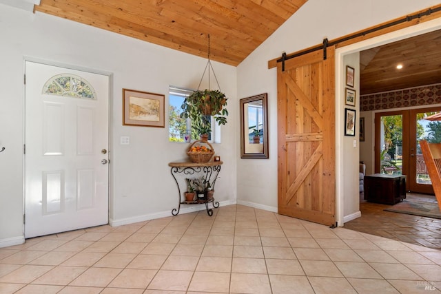 foyer with wooden ceiling, french doors, vaulted ceiling, a barn door, and light tile patterned floors