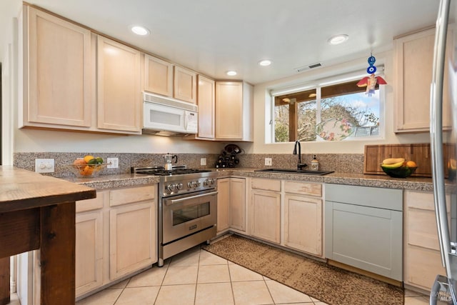 kitchen with high end stove, sink, and light tile patterned floors