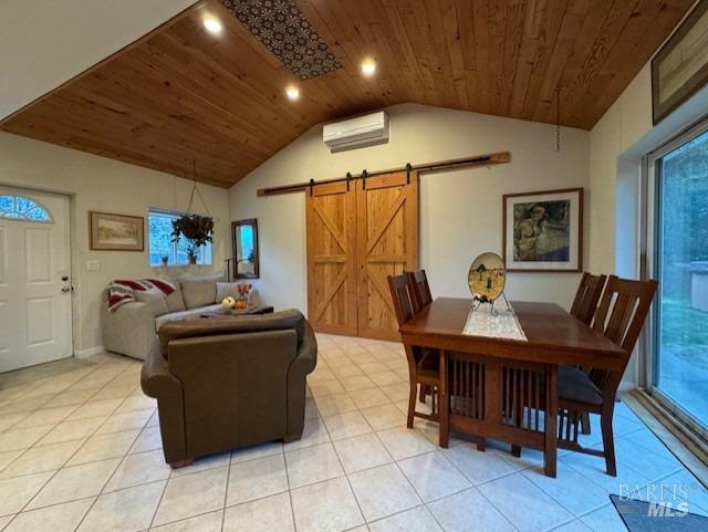 tiled dining room with a barn door, a wall mounted AC, plenty of natural light, lofted ceiling, and wood ceiling