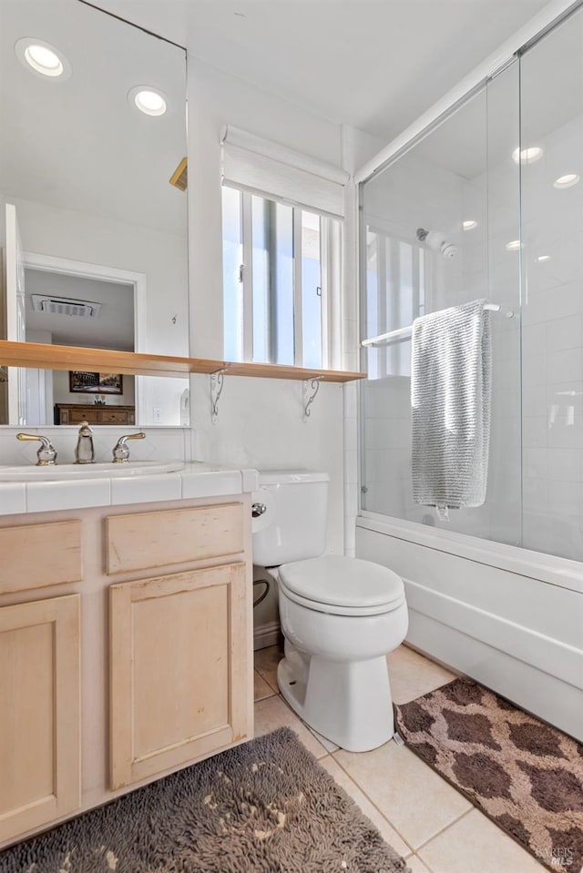 full bathroom featuring tile patterned floors, vanity, toilet, and combined bath / shower with glass door