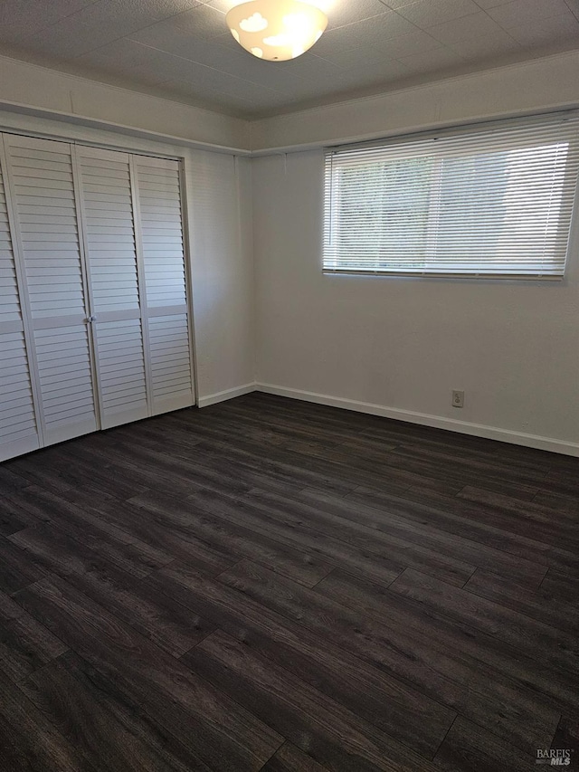 unfurnished bedroom with dark wood-type flooring