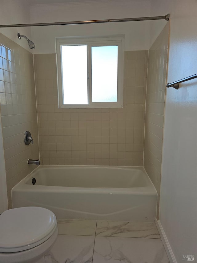 bathroom featuring toilet and tiled shower / bath