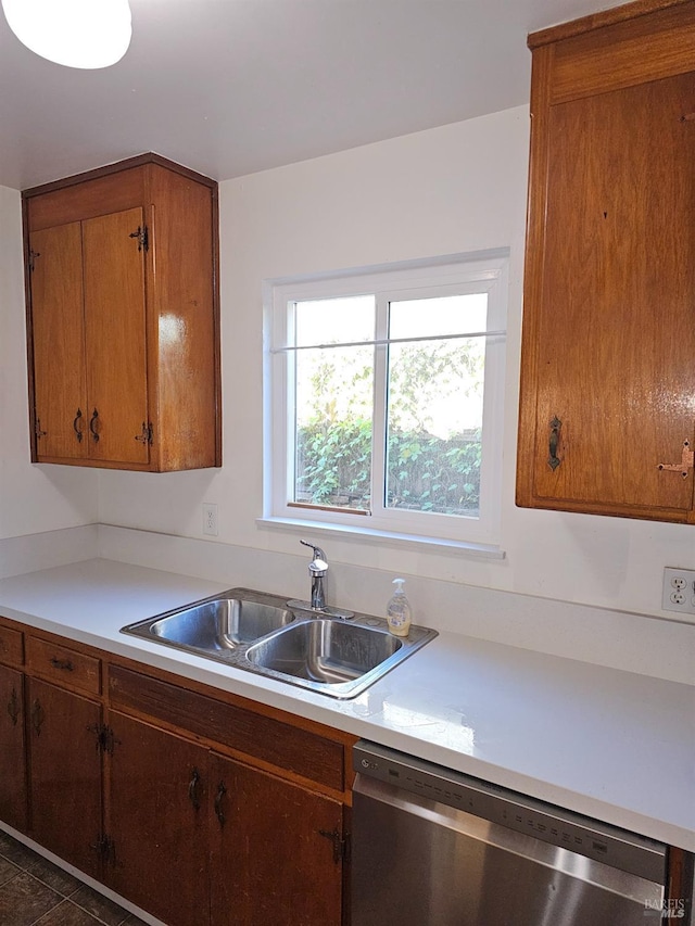 kitchen featuring dishwasher, dark tile patterned flooring, and sink