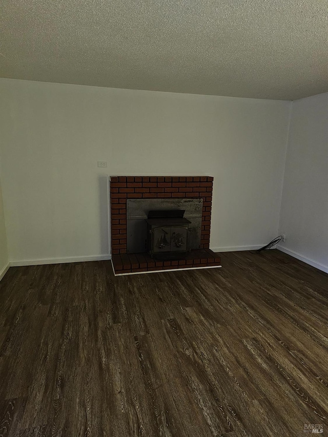 unfurnished living room featuring dark hardwood / wood-style flooring and a textured ceiling