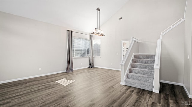 unfurnished living room featuring stairs, visible vents, a chandelier, and wood finished floors