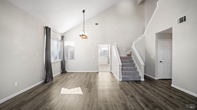 unfurnished living room featuring dark hardwood / wood-style flooring, high vaulted ceiling, and a notable chandelier