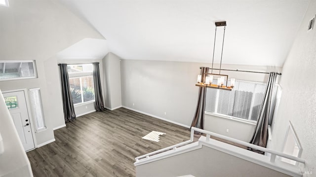 entrance foyer with an inviting chandelier, dark hardwood / wood-style flooring, and vaulted ceiling