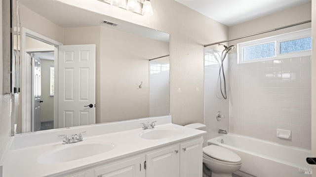 full bathroom with vanity, tiled shower / bath combo, and toilet